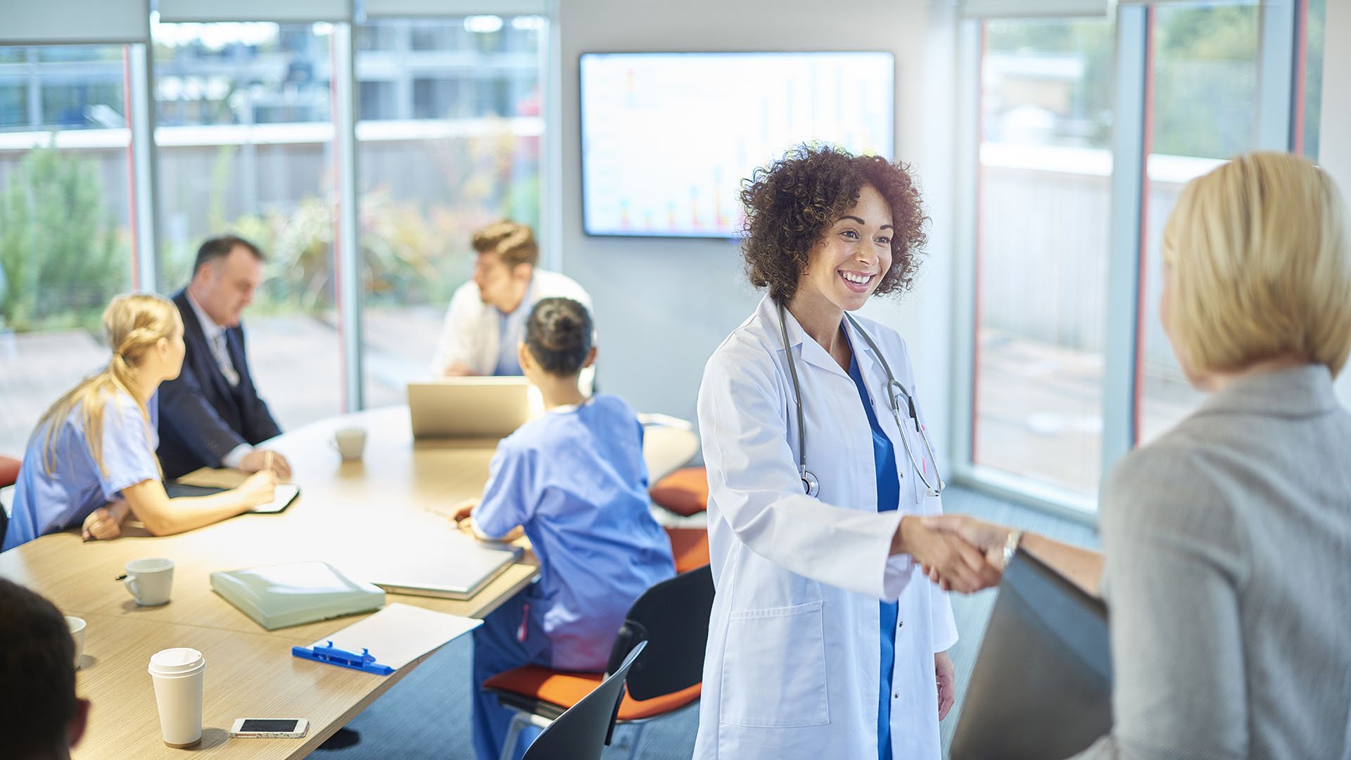 Healthcare executives shaking hands in a boardroom